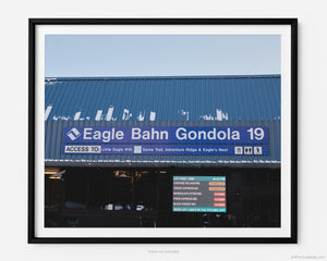 This fine art photography print shows winter in Vail, Colorado at Vail Ski Resort. The iconic Eagle Bahn Gondola, covered in some light snow, lists access to Little Edge #15, Game Trail, Adventure Ridge, and Eagle’s Nest. A digital sign indicates that the lift wait time is 4:53pm and the other lifts are mostly closed for the day.