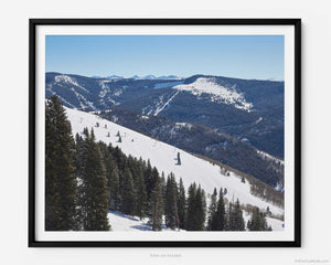 This fine art photography print shows winter in Vail, Colorado at Vail Ski Resort. Looking down the mountain and into the legendary Back Bowl ski area, the High Noon Express ski lift can be viewed in the distance.