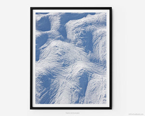 This fine art photography print transports you to winter at Vail Ski Resort in Colorado. As you look down off of the Wildwood Express ski lift, you take in a captivating overhead view of moguls etched in snow on a black diamond ski run by skiers and snowboarders.