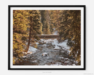 This fine art photography print shows winter in Vail, Colorado at Vail Ski Resort. As the sunsets, a rustic wood bridge spans across the peaceful waterways of Gore Creek. 