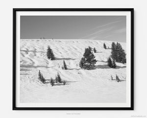 This black and white fine art photography print shows winter in Vail, Colorado at Vail Ski Resort. The air is crisp, and cool as you look off towards the Wildwood Express ski lift, taking in a stunning view of skiers at the top of Kangaroo Cornice's black diamond skin run.