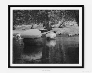 This black and white fine art photography print shows winter in Vail, Colorado at Vail Ski Resort. As sunset peers thru the pines, you see snow pillowed on rocks amidst a peaceful serene waterway of Gore Creek.